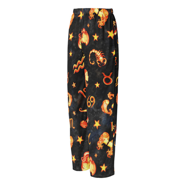 Black pajama pants with orange zodiac symbol pattern on a white background