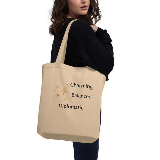 Beige tote bag with text held by a person on a white background