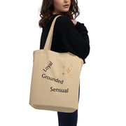Beige tote bag with motivational phrases held by a person on a white background