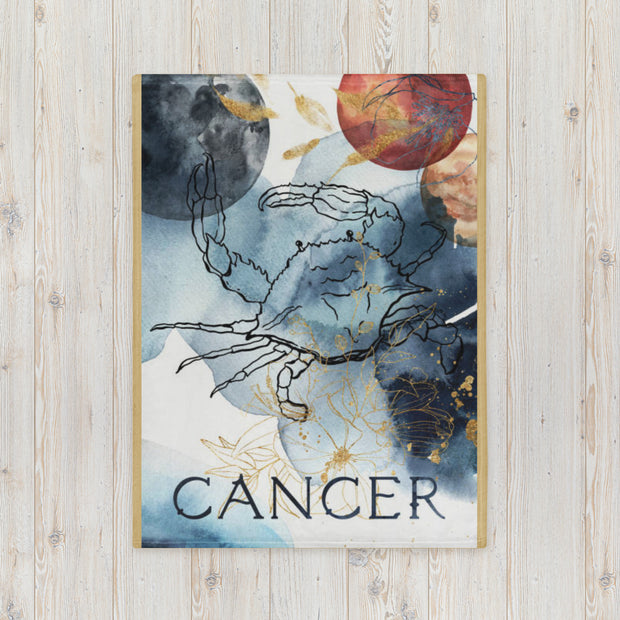 Framed artwork of the Cancer zodiac sign with celestial elements on a wooden surface.